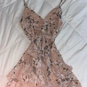 Pink floral mini dress with adjustable straps, low neckline, and ruffle skirt